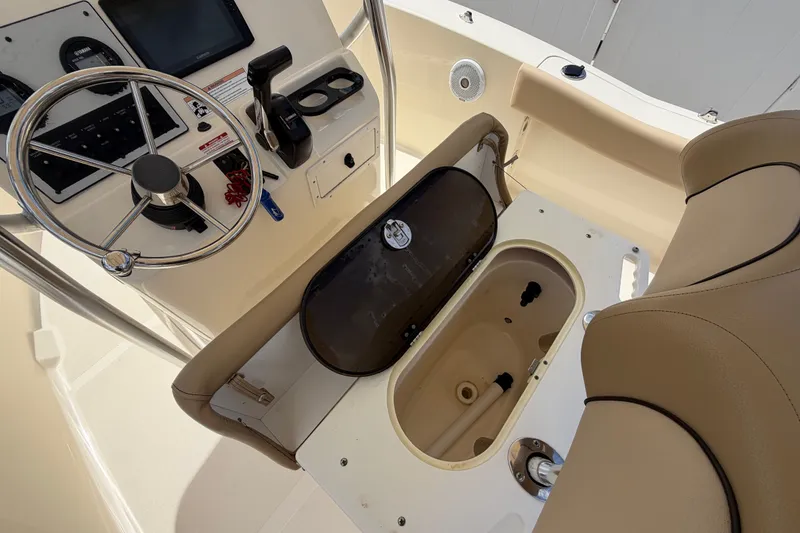 Slide: The Image of 2017 Scout 195 Sportfish boat helm with steering wheel and storage compartment. - 26