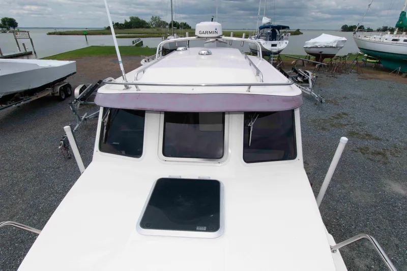 Slide: The Image of 2007 C-Dory 25' Tomcat Catamaran docked near a lake with overcast skies. - 11