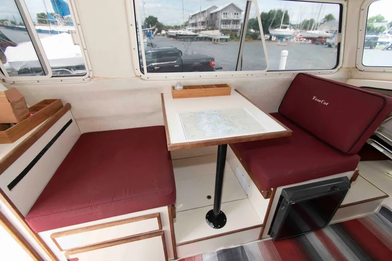 Slide: The Image of Interior of 2007 C-Dory 25' Tomcat Catamaran with red seating and table. - 17