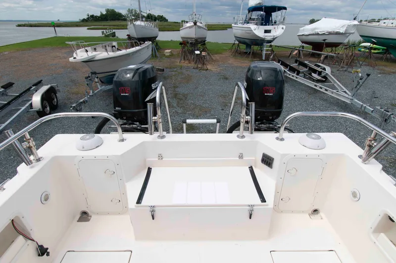 Slide: The Image of 2007 C-Dory 25' Tomcat Catamaran with dual Suzuki 175 engines, docked near other boats. - 8