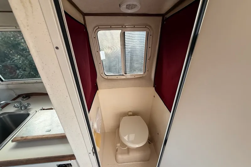Slide: The Image of 2007 C-Dory 25' Tomcat Catamaran bathroom with window and compact design. - 19