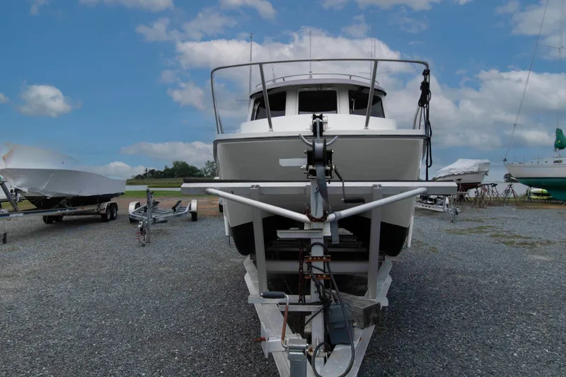 Slide: The Image of 2007 C-Dory 25' Tomcat Catamaran on trailer, parked on gravel lot under blue sky. - 4