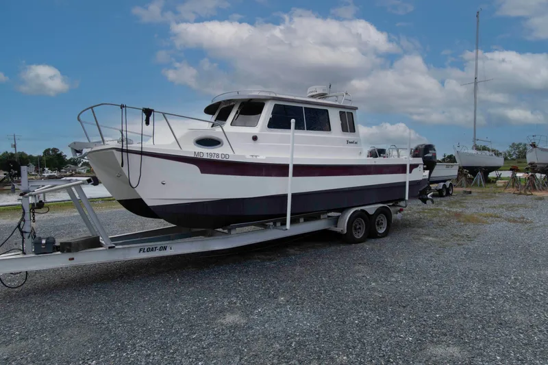 The Image of 2007 C-Dory 25' Tomcat Catamaran on trailer, parked outdoors under a cloudy sky. - 0