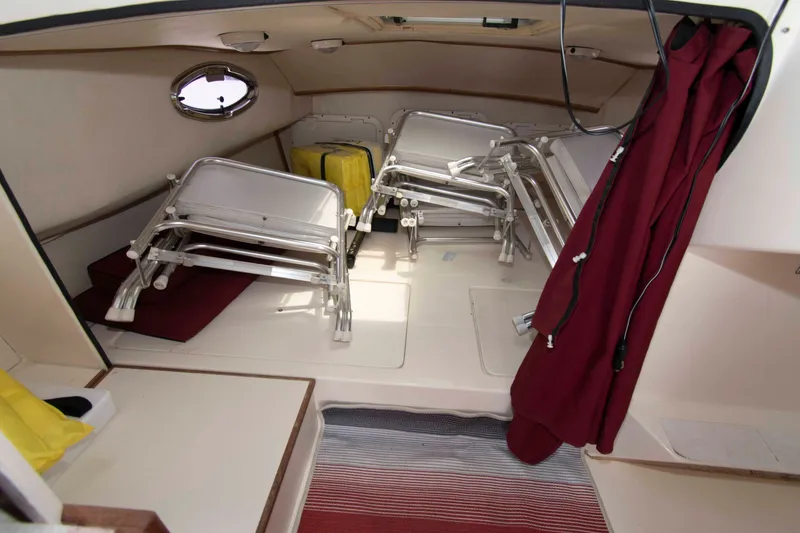 Slide: The Image of Interior of 2007 C-Dory 25' Tomcat Catamaran with folded chairs and red curtain. - 18