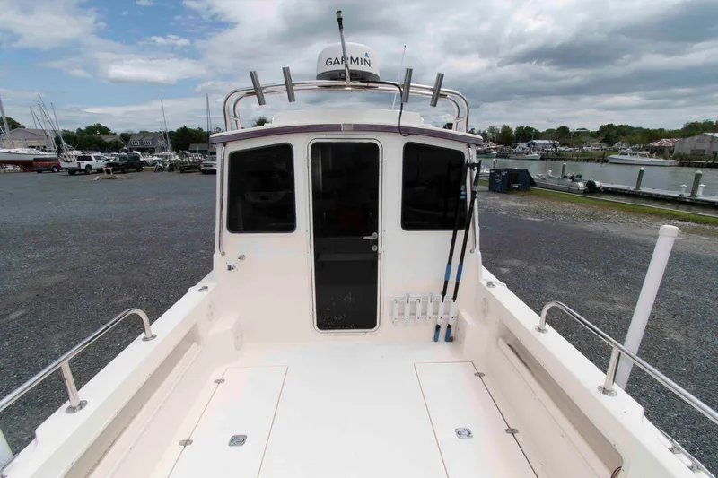 Slide: The Image of 2007 C-Dory 25' Tomcat Catamaran at marina, featuring spacious deck and Garmin equipment. - 6