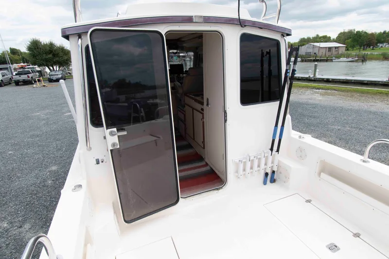 Slide: The Image of 2007 C-Dory 25' Tomcat Catamaran with open cabin door, docked near a marina. - 7