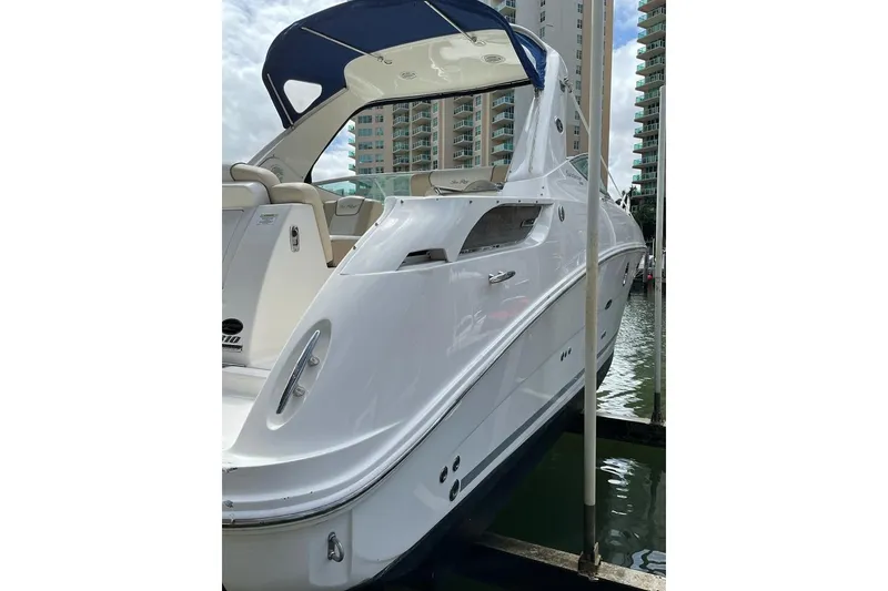Slide: The Image of 2012 Sea Ray Sundancer 310 yacht docked near high-rise buildings. - 1