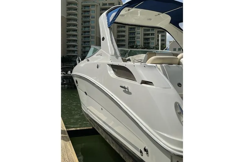Slide: The Image of 2012 Sea Ray Sundancer 310 docked near waterfront buildings. - 2
