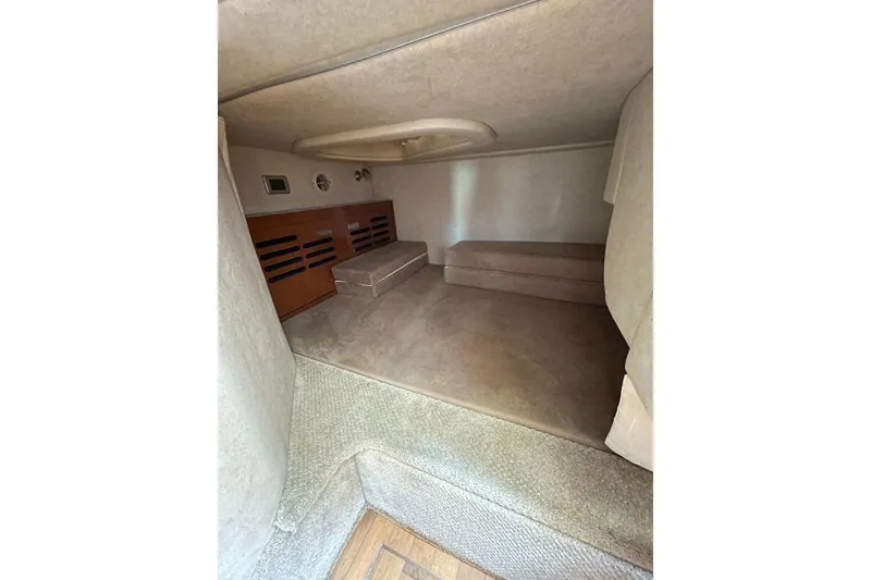 Slide: The Image of Interior cabin of 2012 Sea Ray Sundancer 310, featuring cozy seating and carpeted flooring. - 14