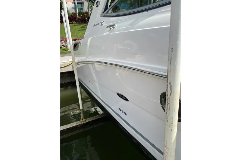 Slide: The Image of 2012 Sea Ray Sundancer 310 yacht docked, showcasing sleek white hull design. - 3