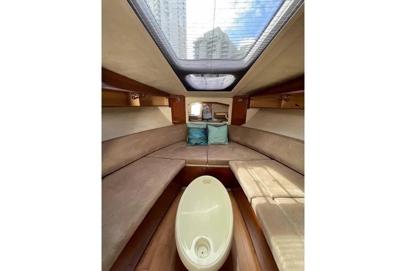 Slide: The Image of Interior of 2012 Sea Ray Sundancer 310, featuring cozy seating and skylight. - 9