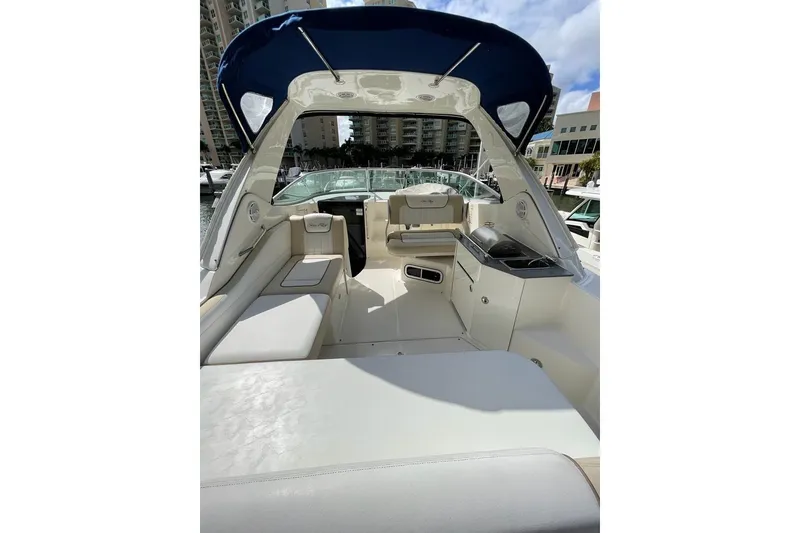 Slide: The Image of 2012 Sea Ray Sundancer 310 boat interior with seating and canopy in marina setting. - 6
