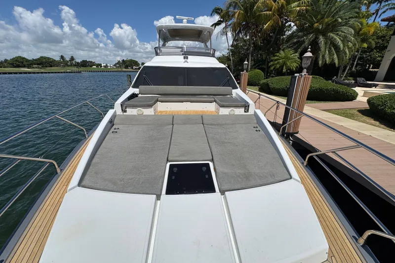 Slide: The Image of 2018 Azimut 66 Flybridge yacht docked, featuring spacious sunbathing area and luxurious design. - 7