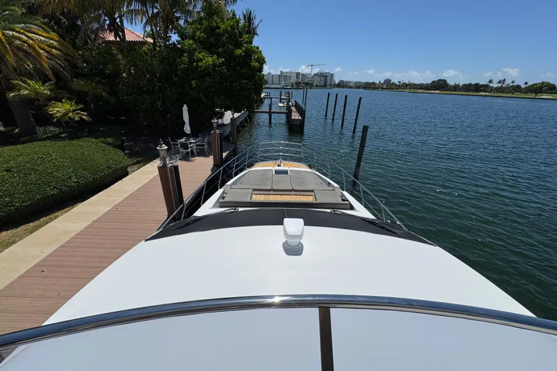 Slide: The Image of 2018 Azimut 66 Flybridge yacht docked by a scenic waterfront. - 4