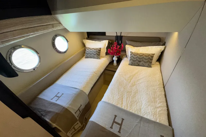 Slide: The Image of Luxurious twin cabin on 2018 Azimut 66 Flybridge yacht with elegant decor and porthole windows. - 42