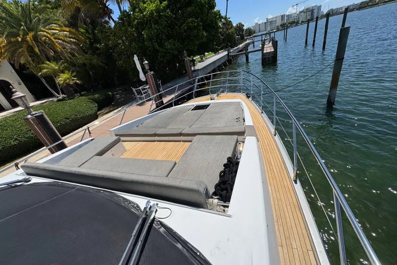 Slide: The Image of 2018 Azimut 66 Flybridge yacht docked, featuring spacious deck and luxurious seating. - 9