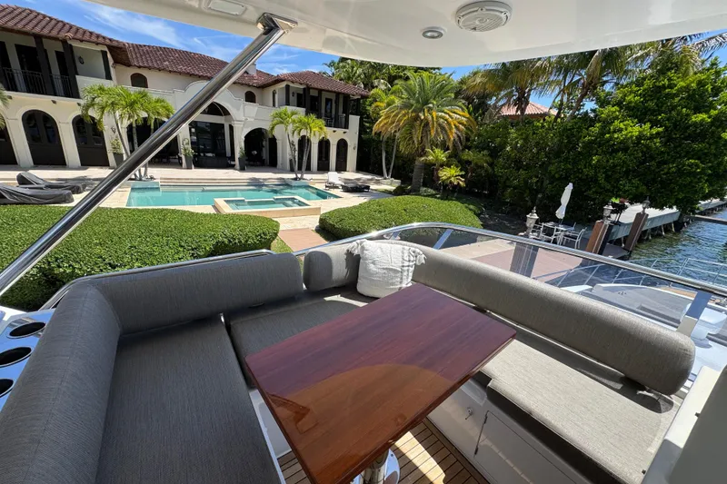 Slide: The Image of Azimut 66 Flybridge 2018 yacht with luxurious seating, overlooking a pool and lush garden. - 16