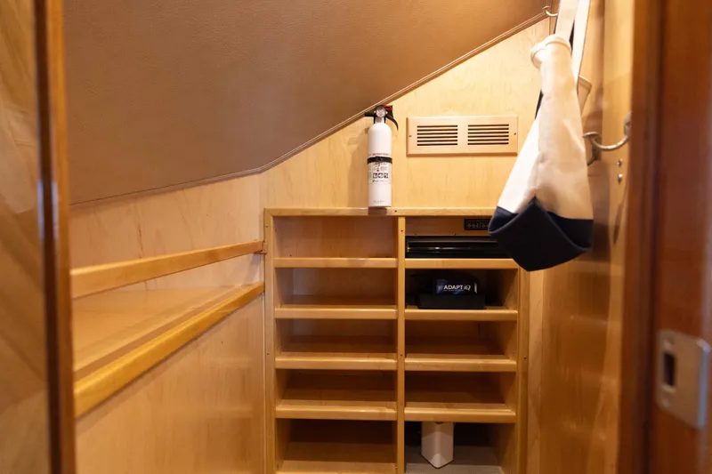 Slide: The Image of Storage area inside 2012 Viking 76 Enclosed Bridge yacht with shelves and fire extinguisher. - 100