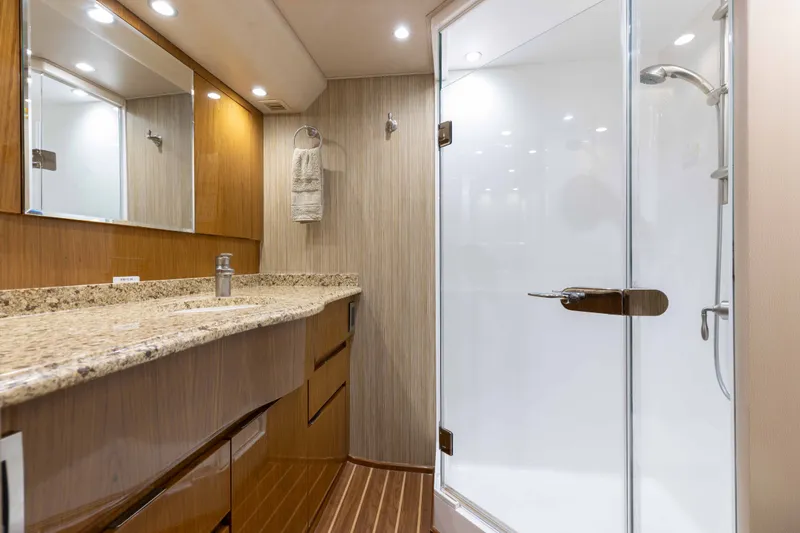 Slide: The Image of Luxurious bathroom in 2012 Viking 76 Enclosed Bridge yacht with granite countertop and glass shower. - 87