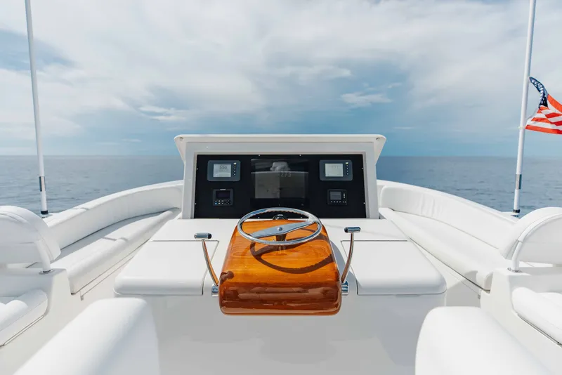 Slide: The Image of Steering area of 2012 Viking 76 Enclosed Bridge yacht with ocean view and American flag. - 49