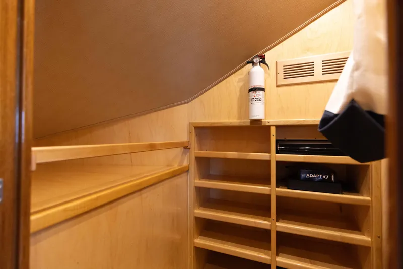 Slide: The Image of Wooden storage area inside 2012 Viking 76 Enclosed Bridge yacht with shelves and fire extinguisher. - 101