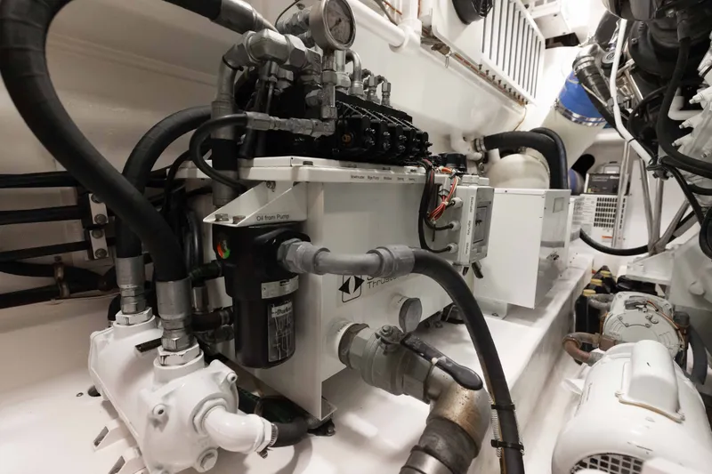Slide: The Image of Engine room of a 2012 Viking 76 Enclosed Bridge yacht, showcasing complex machinery and piping. - 112
