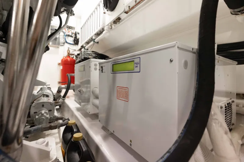 Slide: The Image of Engine room of 2012 Viking 76 Enclosed Bridge yacht, featuring control panels and equipment. - 114