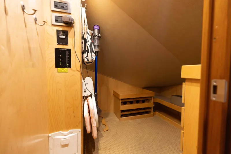 Slide: The Image of Storage area inside 2012 Viking 76 Enclosed Bridge yacht with wooden shelves and vacuum cleaner. - 102