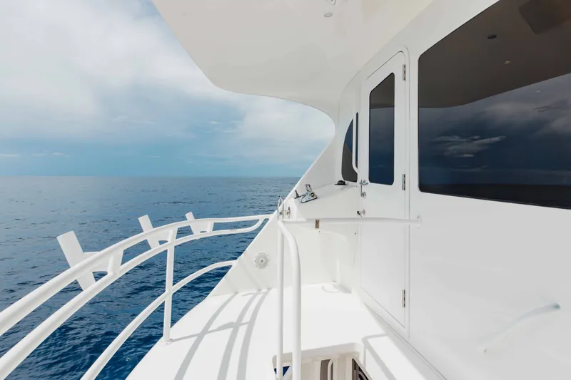 Slide: The Image of 2012 Viking 76 Enclosed Bridge yacht deck with ocean view and sleek white design. - 34