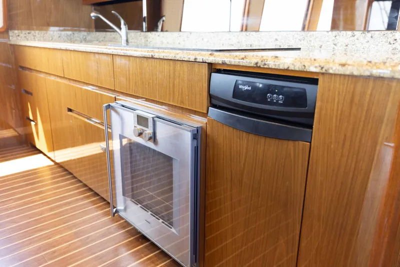 Slide: The Image of Luxurious kitchen interior of 2012 Viking 76 Enclosed Bridge yacht with modern appliances. - 76