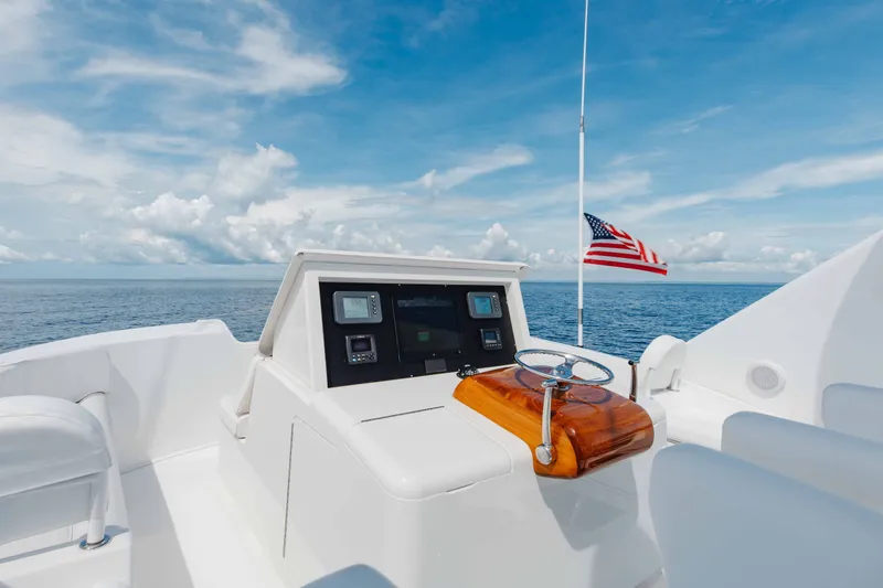 Slide: The Image of Helm of 2012 Viking 76 Enclosed Bridge yacht with ocean view and American flag. - 50