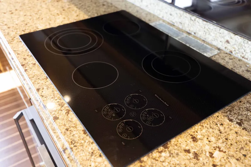 Slide: The Image of Modern black cooktop on granite countertop in 2012 Viking 76 Enclosed Bridge yacht kitchen. - 77