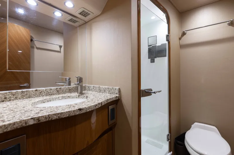 Slide: The Image of Luxurious bathroom in 2012 Viking 76 Enclosed Bridge yacht with granite countertop and glass shower. - 97