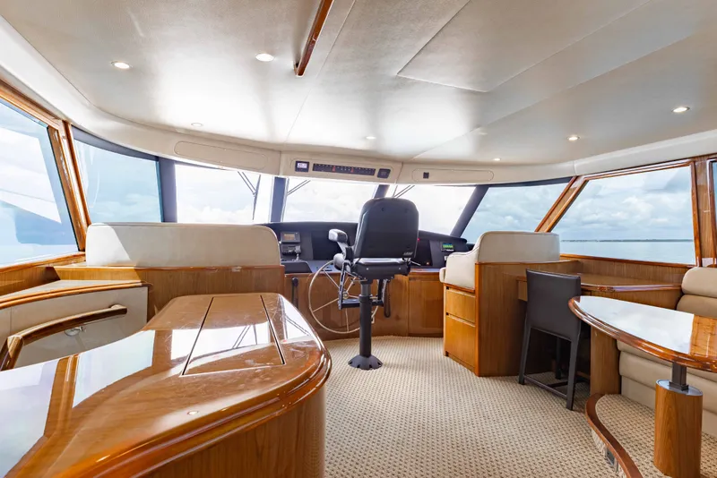 Slide: The Image of Luxurious interior of 2012 Viking 76 Enclosed Bridge yacht with polished wood and panoramic windows. - 56