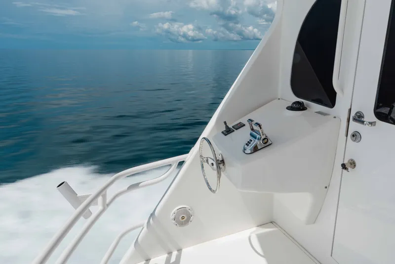 Slide: The Image of Control panel of 2012 Viking 76 Enclosed Bridge yacht on calm ocean waters. - 35