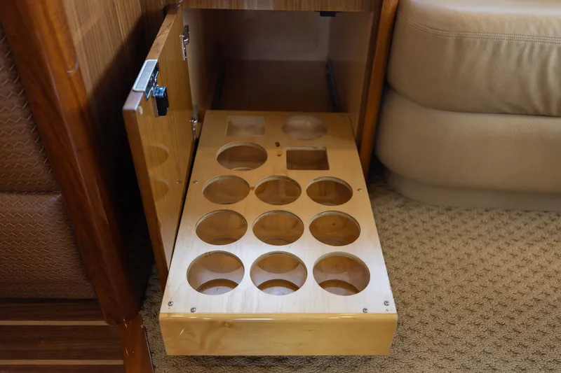 Slide: The Image of Wooden storage drawer with circular compartments in a 2012 Viking 76 Enclosed Bridge yacht. - 68