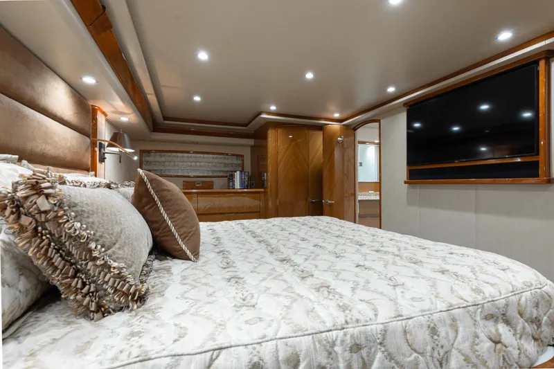 Slide: The Image of Luxurious bedroom interior of 2012 Viking 76 Enclosed Bridge yacht with elegant decor and large TV. - 84