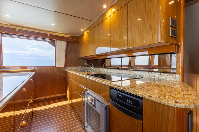 Slide: The Image of Luxurious kitchen interior of 2012 Viking 76 Enclosed Bridge yacht with wood finish and granite countertops. - 75