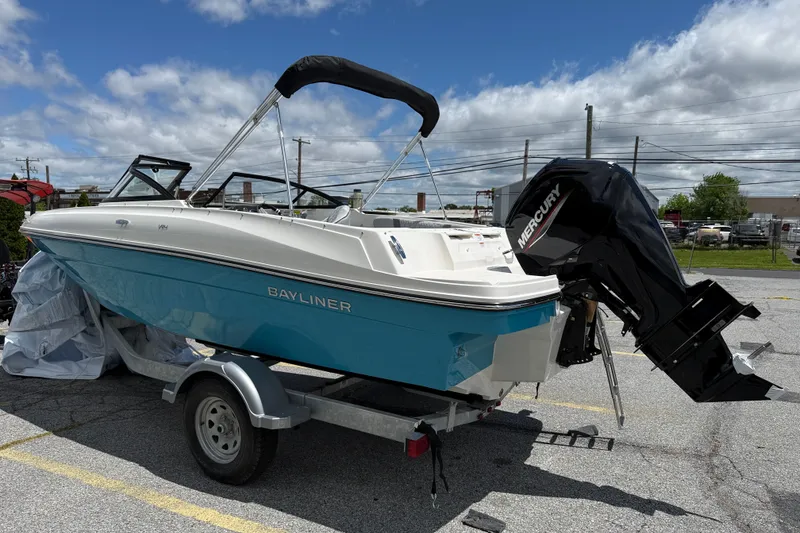 The Image of 2026 Bayliner VR4 Bowrider OB with Mercury outboard engine on trailer, under cloudy sky. - 1