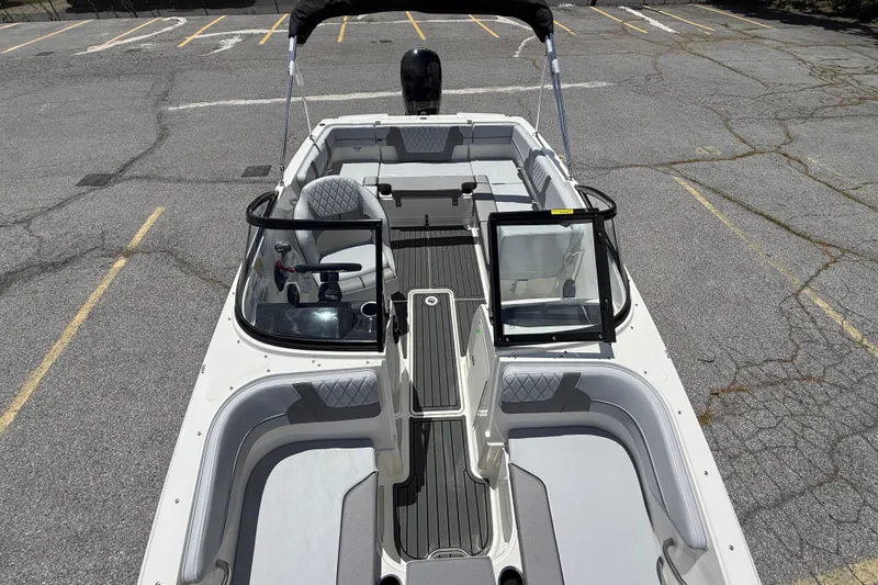 Slide: The Image of 2026 Bayliner VR4 Bowrider OB with open deck and seating, parked on asphalt. - 10