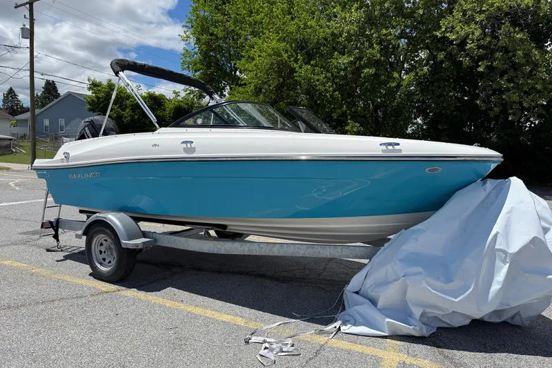 Slide: The Image of 2026 Bayliner VR4 Bowrider OB on trailer, blue and white design, parked outdoors. - 11