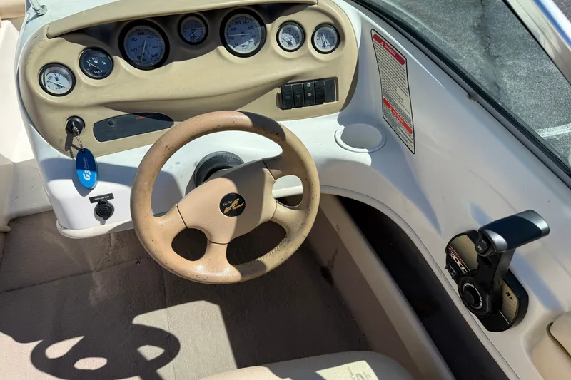 Slide: The Image of Interior dashboard of a 2000 Sea Ray 180 Bow Rider boat, featuring steering wheel and gauges. - 15