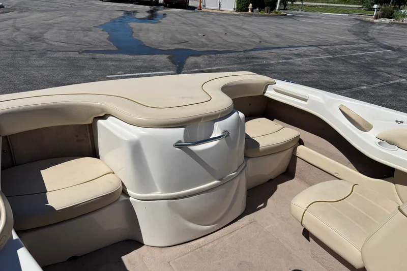 Slide: The Image of 2000 Sea Ray 180 Bow Rider interior with beige seating and storage compartments. - 10