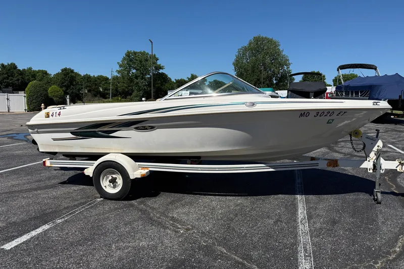 Slide: The Image of 2000 Sea Ray 180 Bow Rider boat on trailer in parking lot. - 5