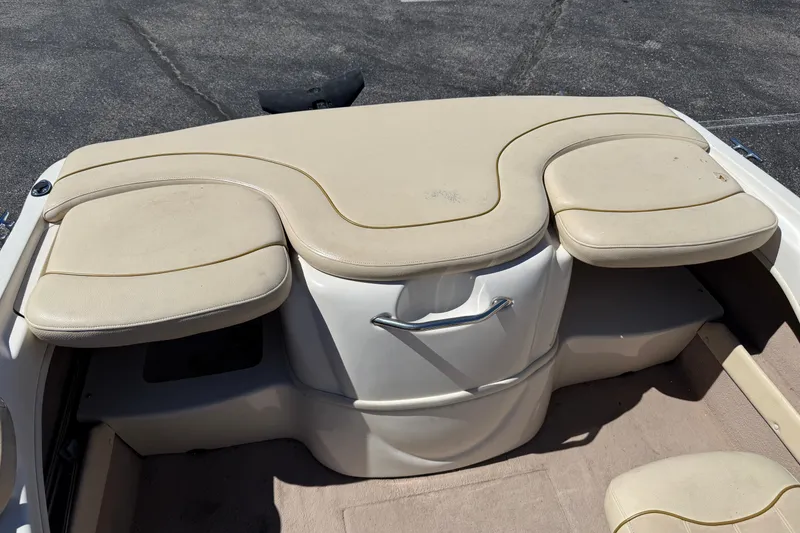 Slide: The Image of 2000 Sea Ray 180 Bow Rider interior with beige seating and storage compartment. - 18