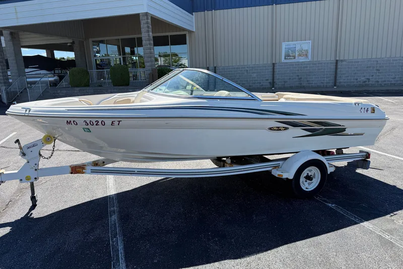 Slide: The Image of 2000 Sea Ray 180 Bow Rider boat on trailer, parked outside a building. - 4
