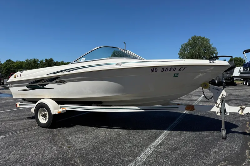 Slide: The Image of 2000 Sea Ray 180 Bow Rider boat on trailer in parking lot, clear sky background. - 3