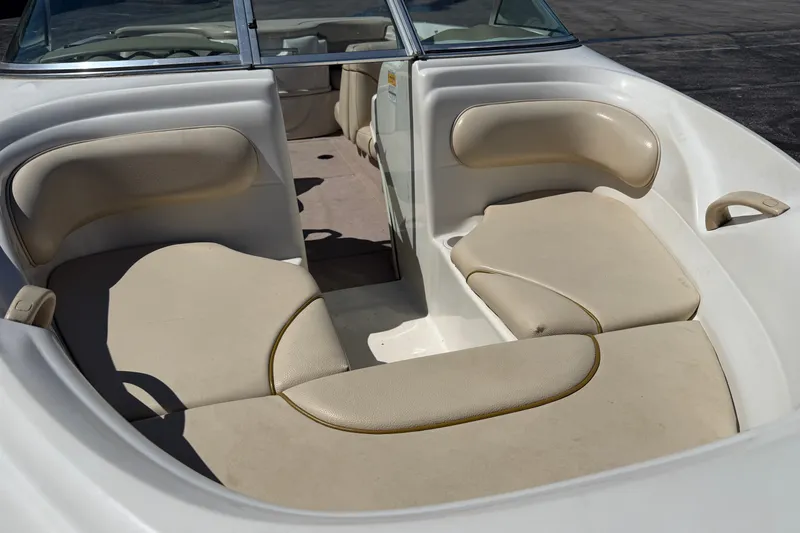 Slide: The Image of 2000 Sea Ray 180 Bow Rider interior with beige seating and open bow layout. - 9