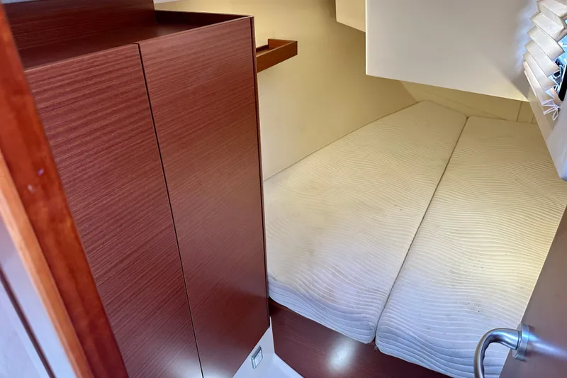 Slide: The Image of Cozy cabin interior of 2021 Hanse 348 yacht with wooden cabinetry and cushioned bed. - 25