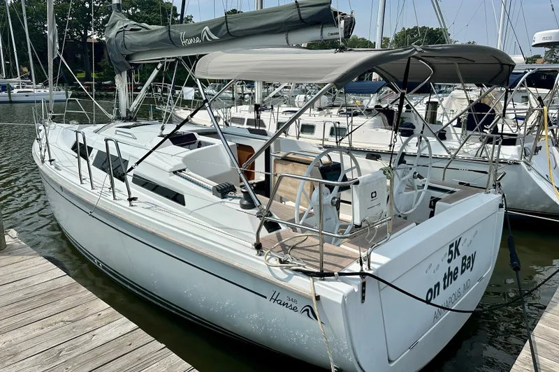 Slide: The Image of 2021 Hanse 348 sailboat docked at marina, featuring sleek design and spacious cockpit. - 8